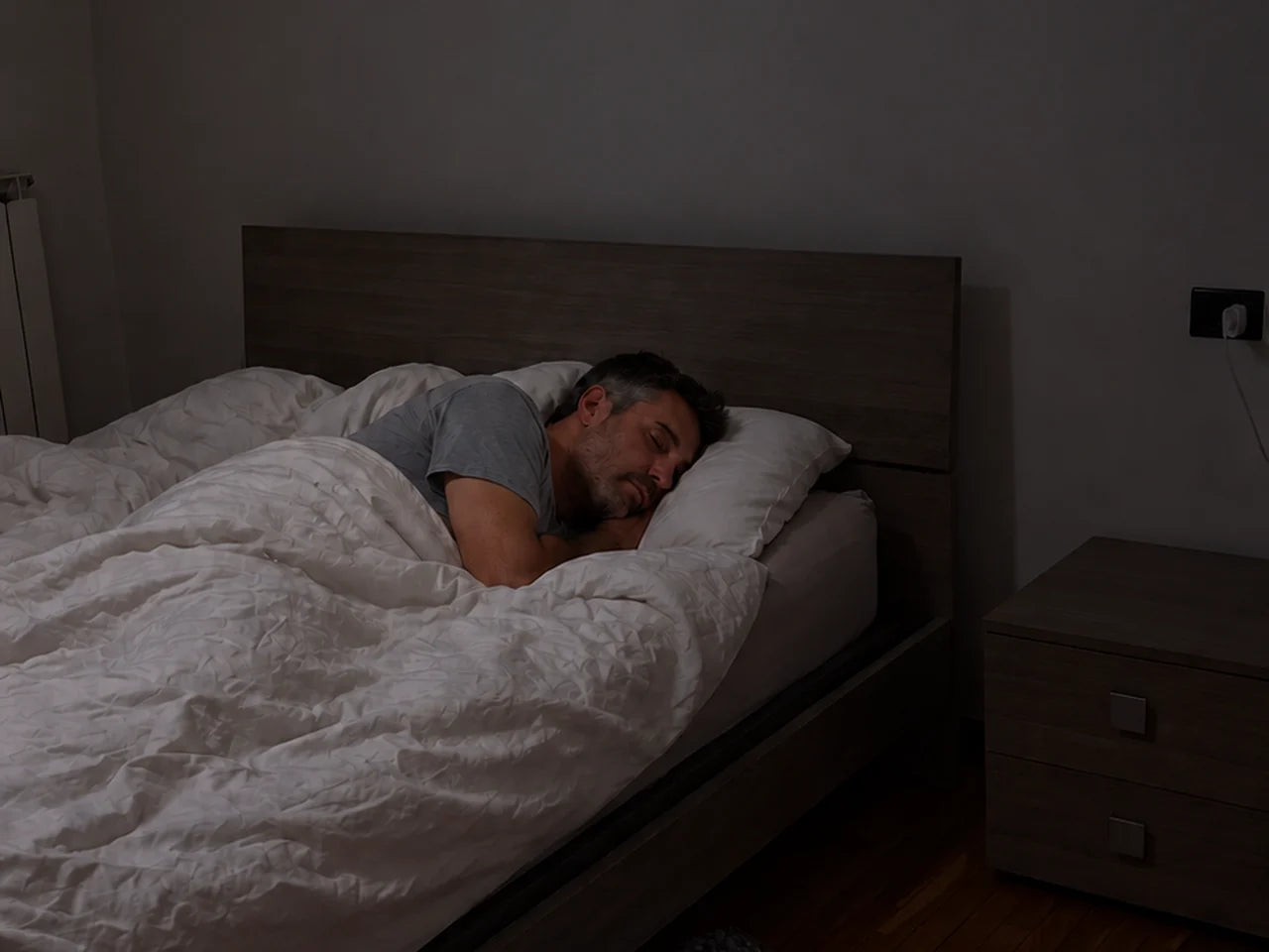 Mann schläft im abgedunkelten Schlafzimmer