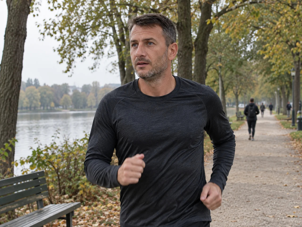 Mann joggt an einem Herbstmorgen am Fluss entlang